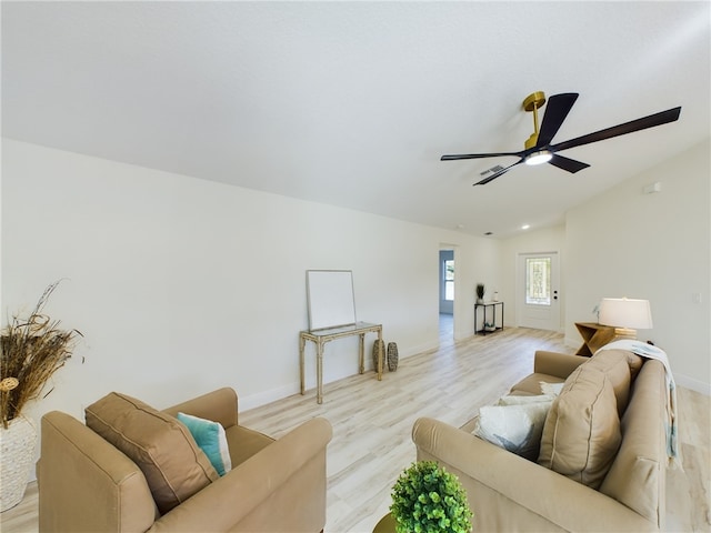 living area featuring baseboards, a ceiling fan, light wood-type flooring, and lofted ceiling