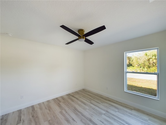 unfurnished room featuring a ceiling fan, baseboards, and light wood-style floors