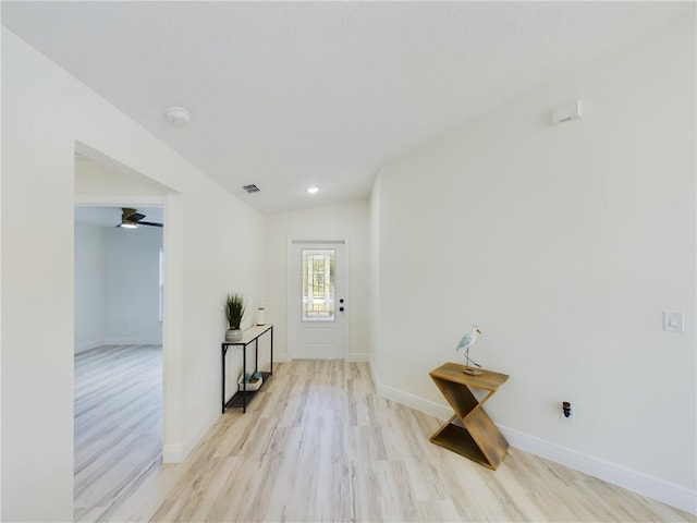 interior space featuring light wood-style floors, a ceiling fan, baseboards, and visible vents