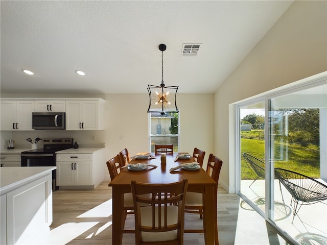 dining room with visible vents, light wood finished floors, lofted ceiling, an inviting chandelier, and recessed lighting