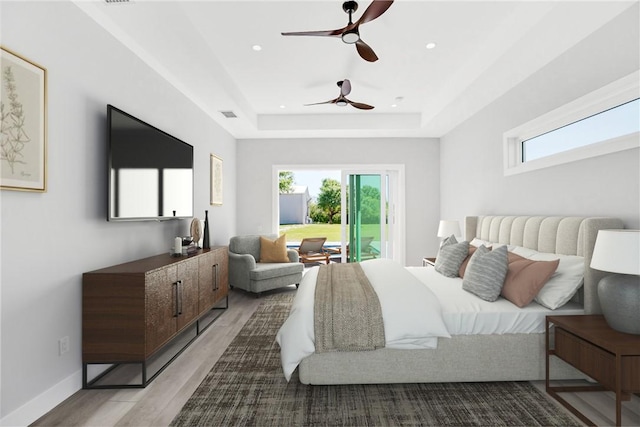 7205 Kamelya St SW, Vero Beach, FL 32968 - bedroom featuring a tray ceiling, access to outside, multiple windows, and wood finished floors