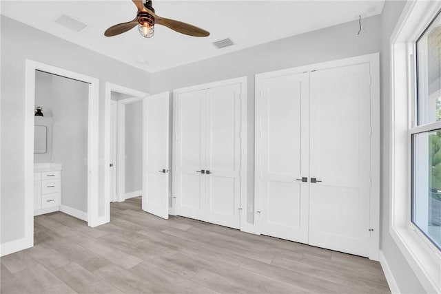 7205 Kamelya St SW, Vero Beach, FL 32968 - unfurnished bedroom featuring light wood-style floors, baseboards, visible vents, two closets, and ceiling fan