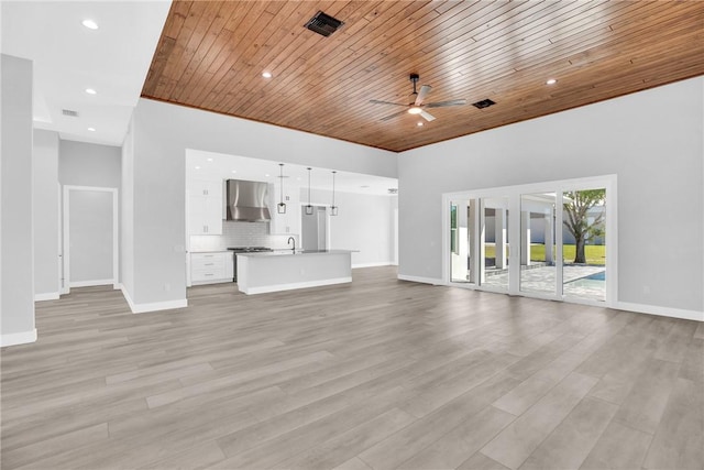 7205 Kamelya St SW, Vero Beach, FL 32968 - unfurnished living room with baseboards, wooden ceiling, ceiling fan, and light wood-style floors