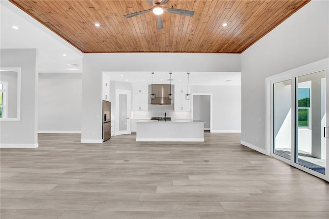 7205 Kamelya St SW, Vero Beach, FL 32968 - unfurnished living room with a ceiling fan, wood ceiling, baseboards, and light wood-type flooring