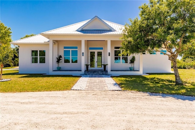 7205 Kamelya St SW, Vero Beach, FL 32968 - view of front of property featuring metal roof, a front yard, a standing seam roof, and french doors