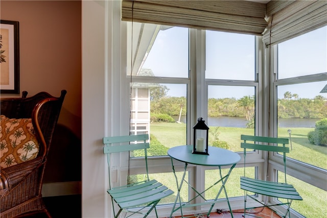 sunroom / solarium with a water view and a healthy amount of sunlight