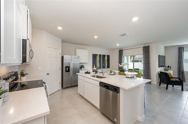 kitchen with white cabinets, a kitchen island with sink, stainless steel appliances, and a sink