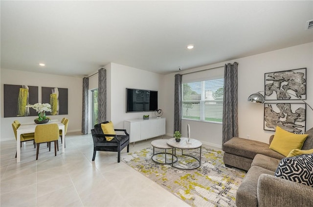 living room featuring light tile patterned floors, visible vents, baseboards, and recessed lighting