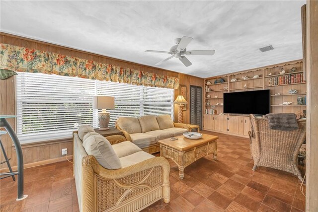 843 22nd Pl, Vero Beach, FL 32960 - living room featuring wooden walls, a ceiling fan, and built in shelves