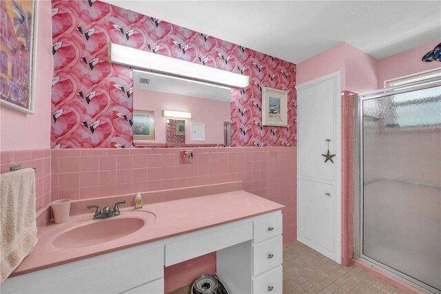 843 22nd Pl, Vero Beach, FL 32960 - full bath with tile walls, vanity, a shower stall, a wainscoted wall, and wallpapered walls