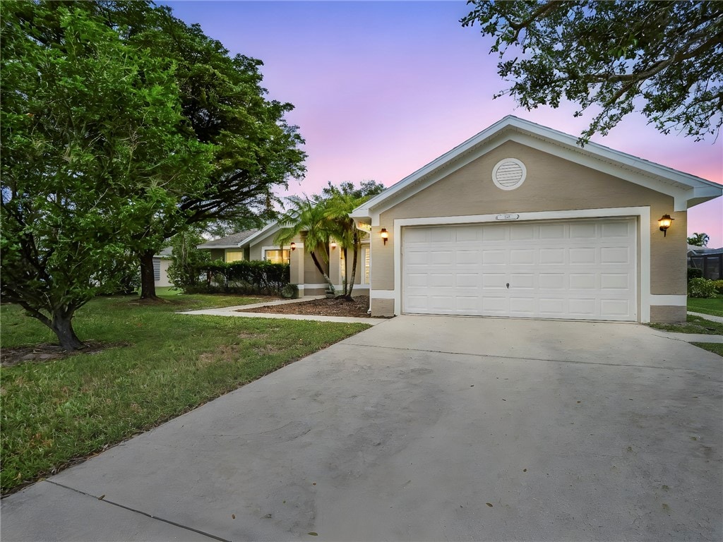 ranch-style home with a lawn and a garage