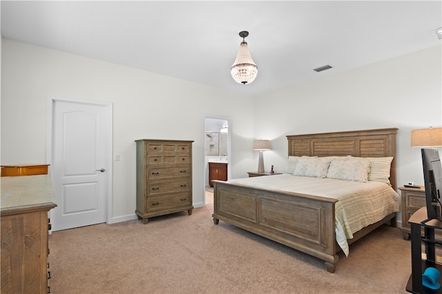 carpeted bedroom with an inviting chandelier and ensuite bath