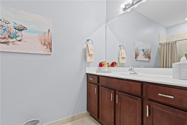 bathroom featuring tile patterned flooring, vanity, and walk in shower