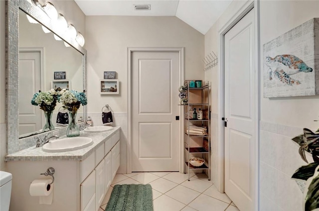 bathroom with tile patterned floors, toilet, vaulted ceiling, and vanity