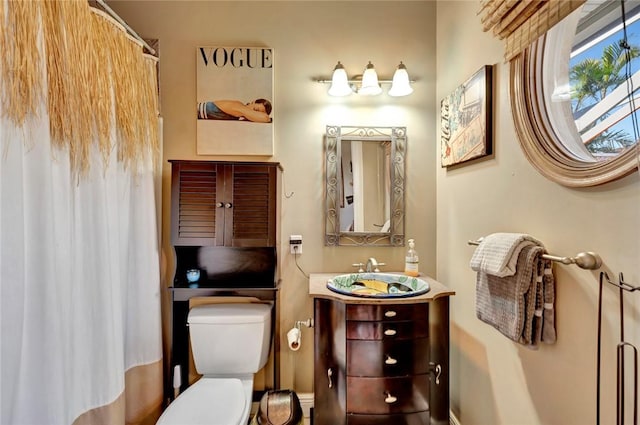 bathroom featuring walk in shower, vanity, and toilet