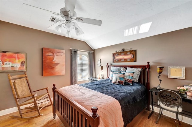 bedroom with lofted ceiling, ceiling fan, and light wood-type flooring