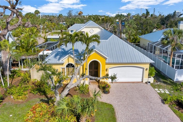 view of front of home featuring a garage and glass enclosure