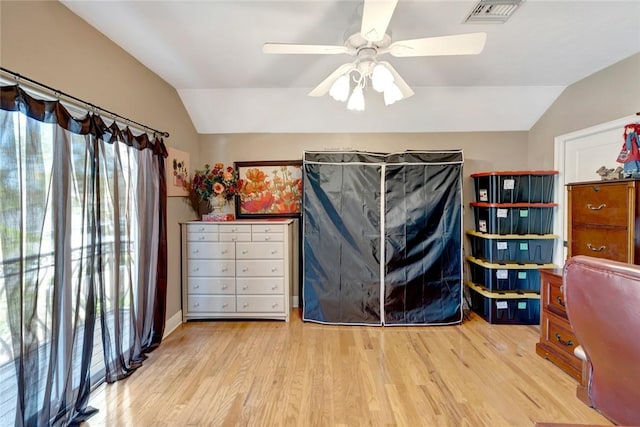 bedroom with ceiling fan, vaulted ceiling, and light hardwood / wood-style flooring