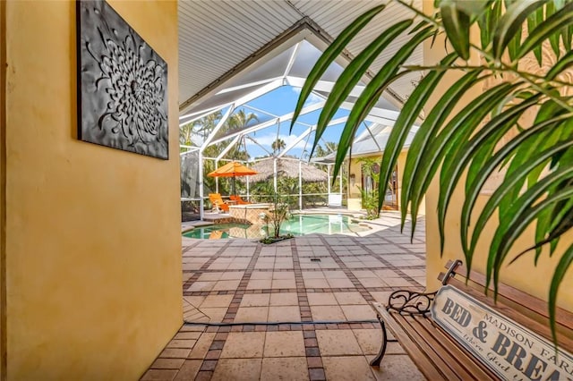 exterior space featuring a swimming pool with hot tub and glass enclosure