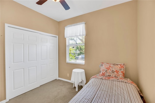 bedroom with ceiling fan, a closet, and light colored carpet