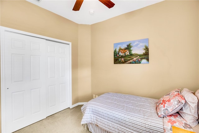 carpeted bedroom with ceiling fan and a closet