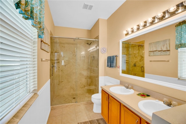 bathroom with toilet, vanity, tile patterned floors, and walk in shower