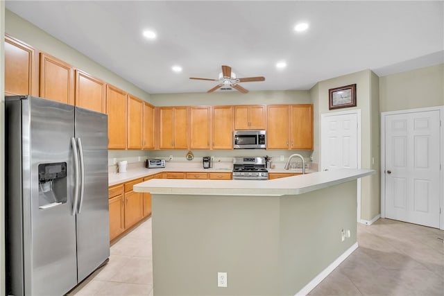 kitchen with ceiling fan, light tile patterned flooring, an island with sink, and appliances with stainless steel finishes