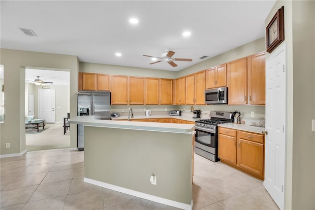 kitchen featuring a center island with sink, light tile patterned flooring, sink, and stainless steel appliances