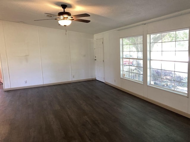 10186 NE 30th St, Okeechobee, FL 34974 - empty room with a ceiling fan, dark wood-style floors, a textured ceiling, plenty of natural light, and baseboards