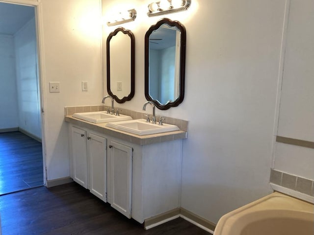 10186 NE 30th St, Okeechobee, FL 34974 - full bathroom with wood finished floors, baseboards, and double vanity