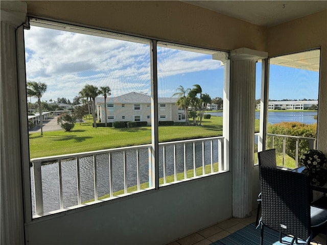 sunroom featuring a water view