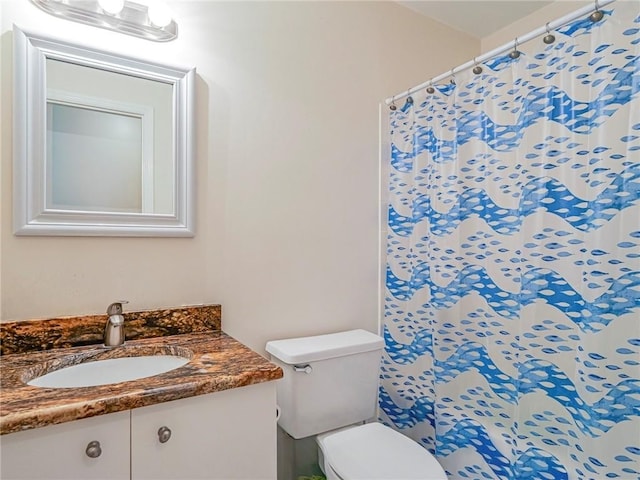bathroom featuring toilet, a shower with curtain, and vanity