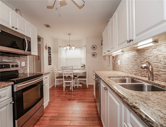 kitchen with white cabinets, appliances with stainless steel finishes, and sink