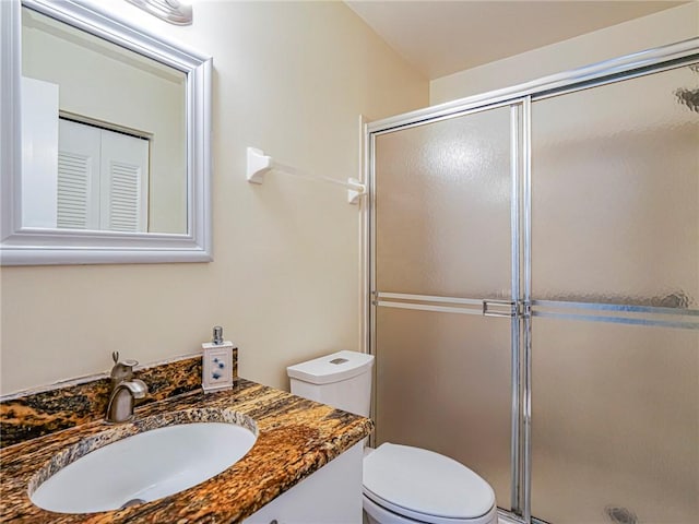 bathroom featuring vanity, toilet, and a stall shower