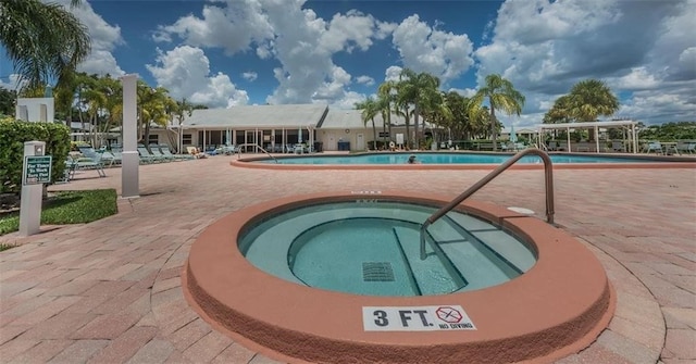 view of swimming pool with a hot tub