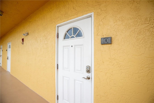 property entrance with stucco siding