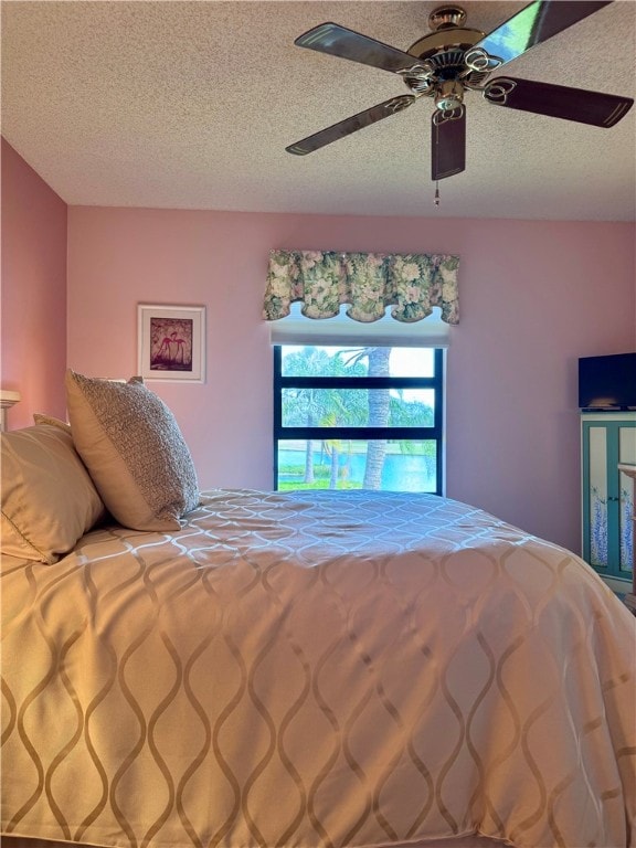 bedroom with a textured ceiling and ceiling fan