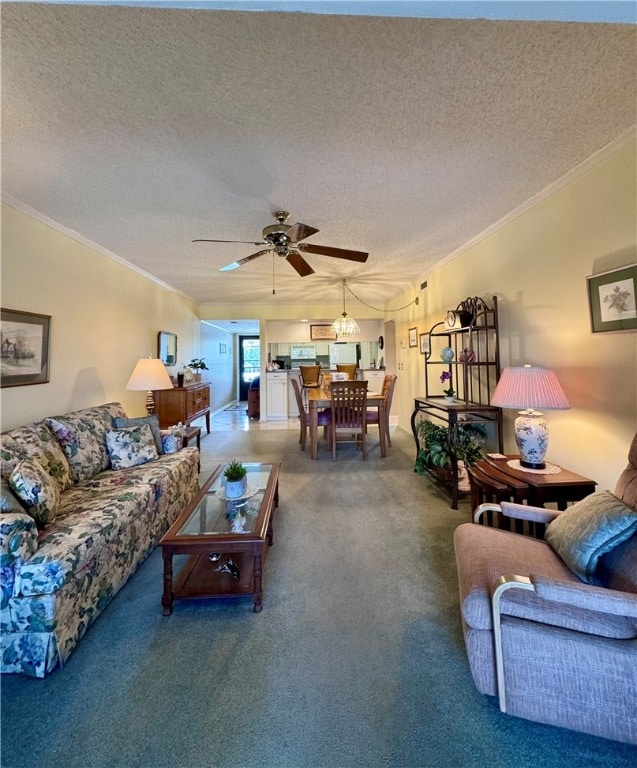 living room with a textured ceiling, ceiling fan, ornamental molding, and carpet flooring