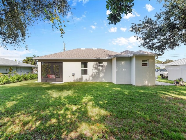 rear view of house featuring a lawn