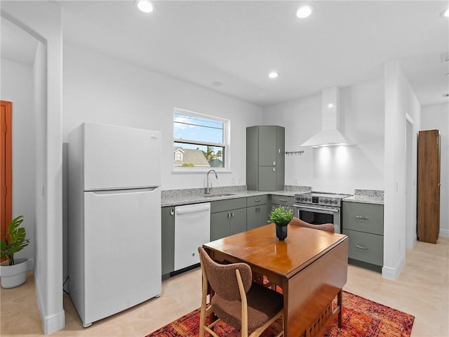 kitchen featuring sink, white appliances, wall chimney range hood, and gray cabinets