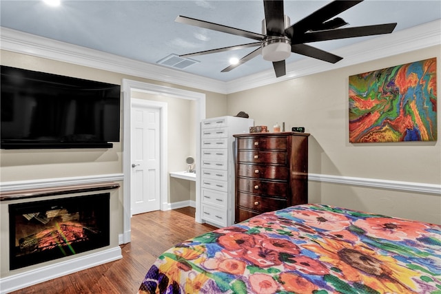 bedroom featuring hardwood / wood-style floors, ceiling fan, and crown molding