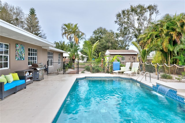 view of pool with a grill, a patio, and pool water feature