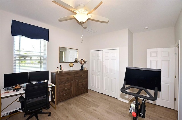 office area with ceiling fan, light wood finished floors, and visible vents