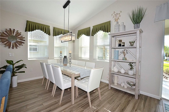 dining space featuring baseboards, vaulted ceiling, and wood finished floors