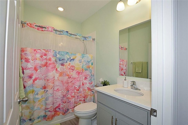 bathroom with recessed lighting, toilet, shower / bathtub combination with curtain, and vanity