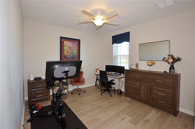 office space with light wood-style floors, baseboards, visible vents, and a ceiling fan