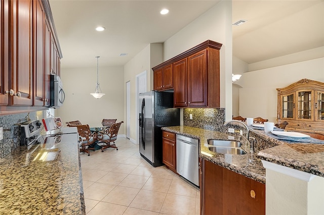 kitchen featuring stainless steel appliances, decorative backsplash, sink, decorative light fixtures, and dark stone countertops