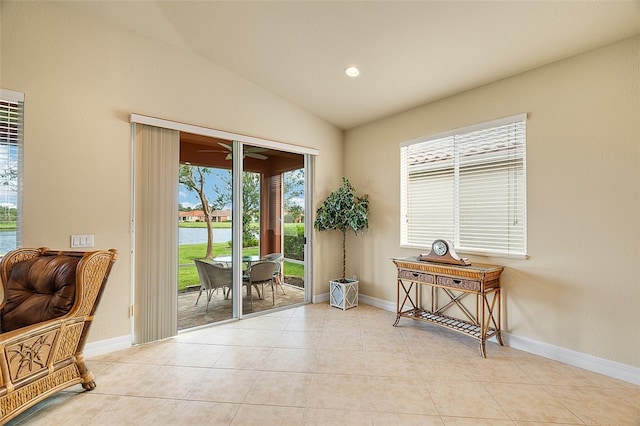 doorway with light tile patterned floors, a water view, and lofted ceiling