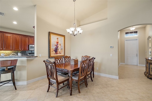 tiled dining area with a chandelier and vaulted ceiling