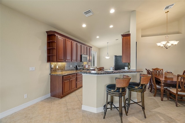 kitchen with an inviting chandelier, kitchen peninsula, appliances with stainless steel finishes, and lofted ceiling